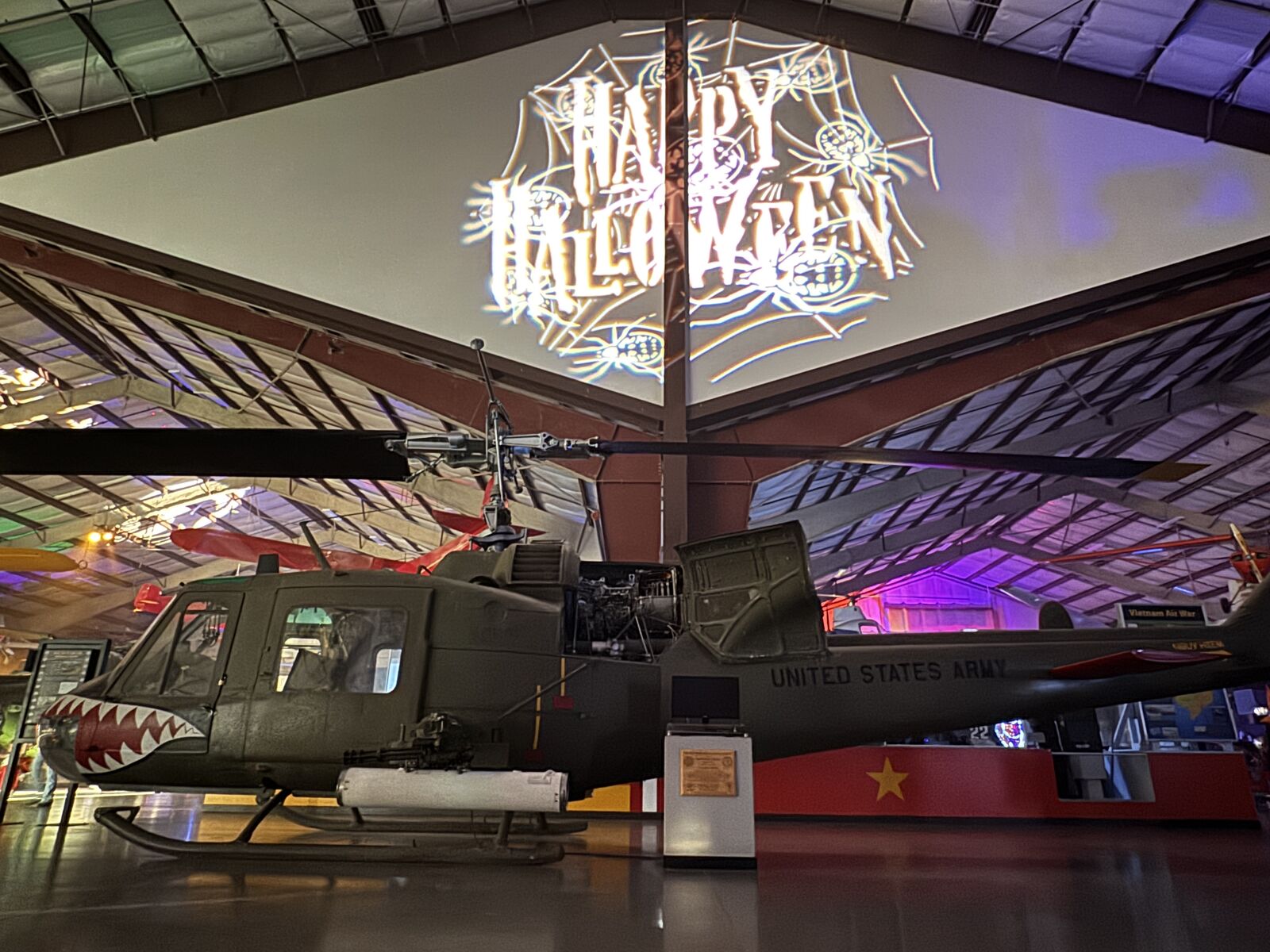 Halloween projection above a helicopter inside the museum