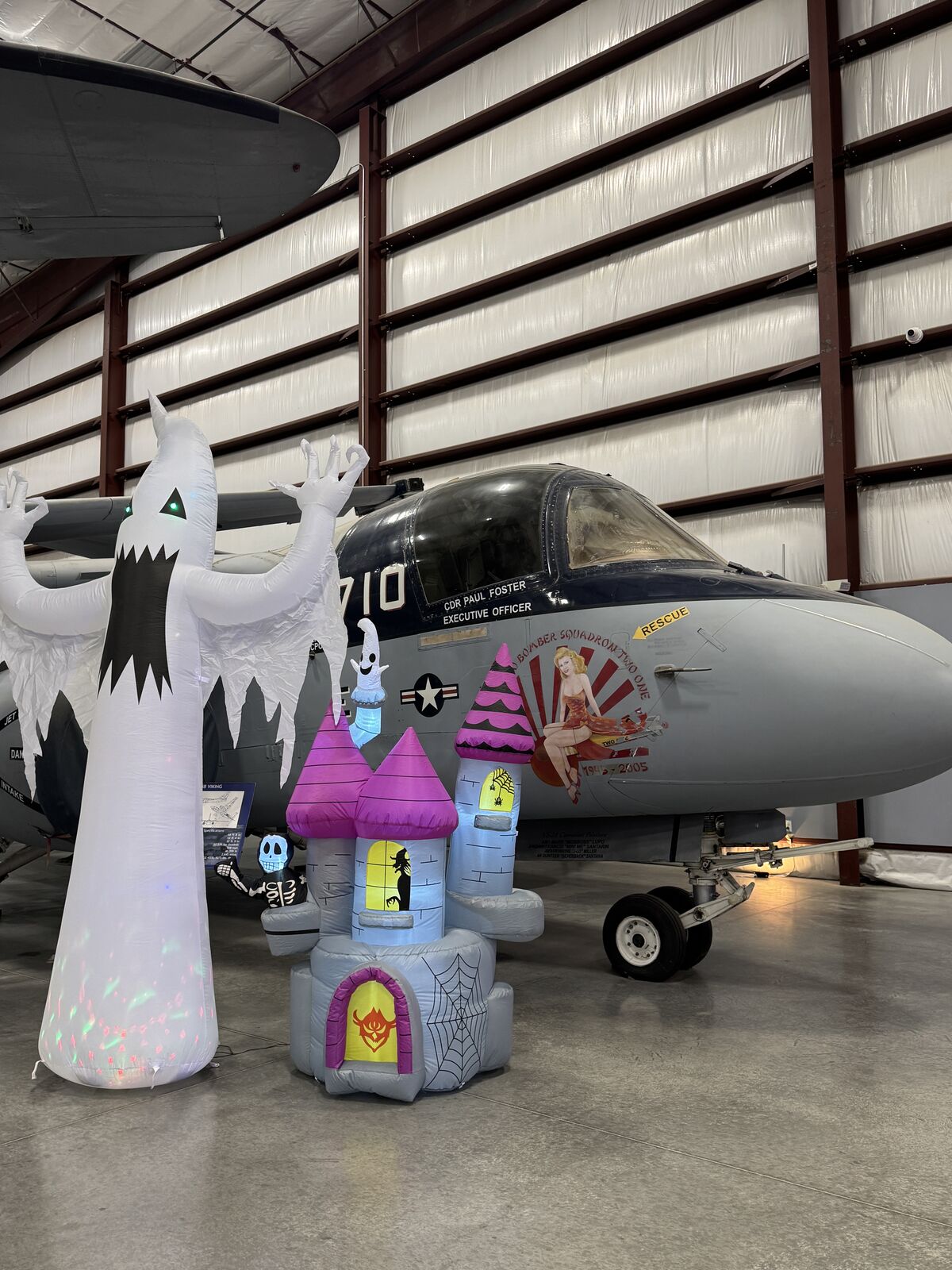 Inflatable ghost and castle next to a Navy aircraft